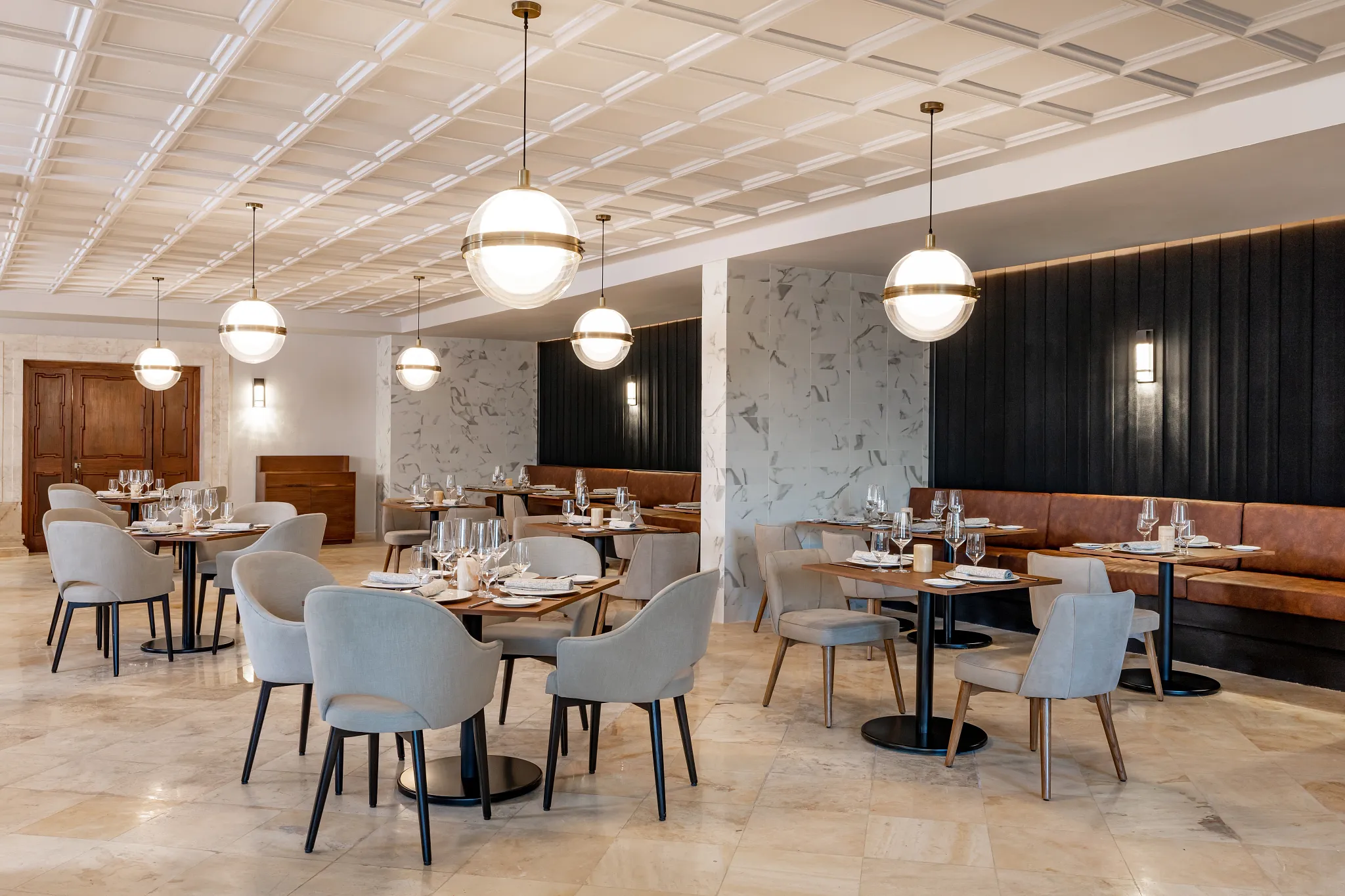 Capri Grille at Hyatt Zilara Riviera Maya featuring a chic modern dining room with marble accents, warm lighting, and elegant table settings.