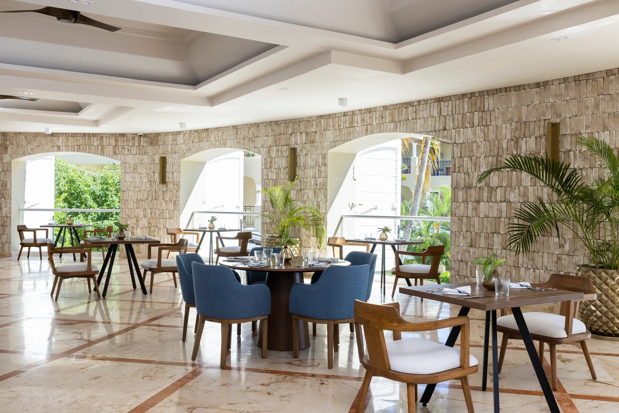 El Comedor buffet restaurant at Hyatt Zilara Riviera Maya featuring an elegant open-air dining space with stone walls, modern seating, and garden views.