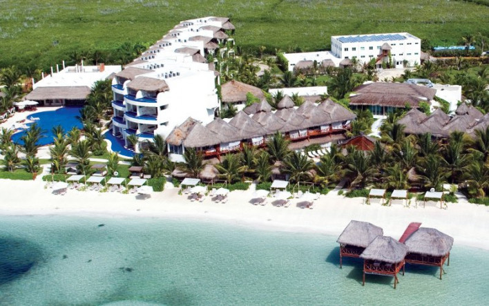 El Dorado Maroma adults-only beachfront resort on Maroma Beach with overwater bungalows, palapa-style architecture, and turquoise waters.