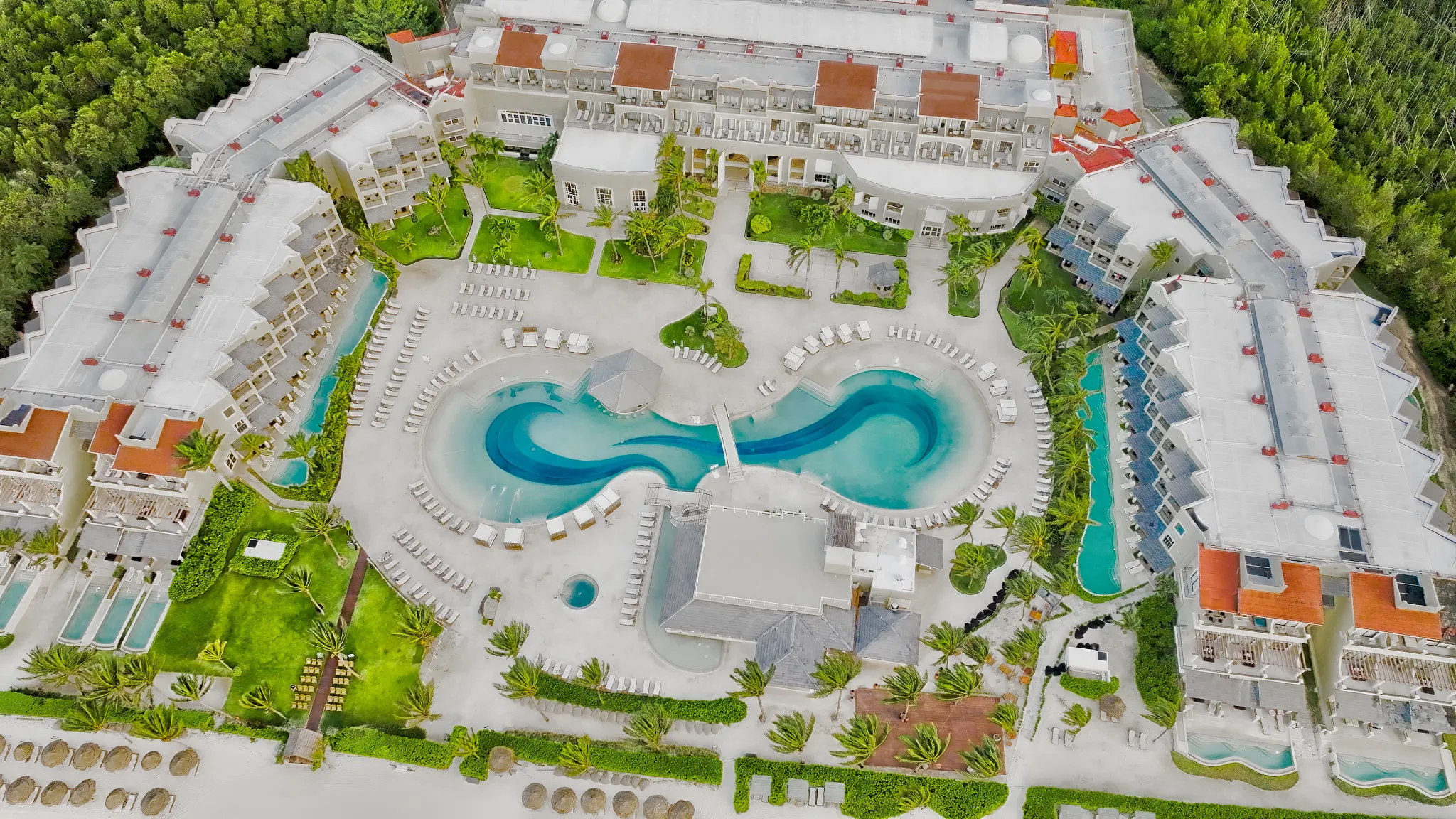 Aerial view of Hyatt Zilara Riviera Maya showing unique pool design, swim-up areas, and surrounding resort buildings.