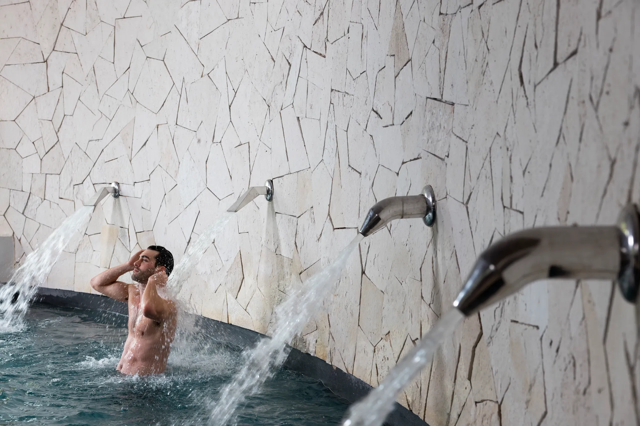Guest enjoying hydrotherapy water features at Hyatt Zilara Riviera Maya spa, designed for relaxation and muscle recovery.