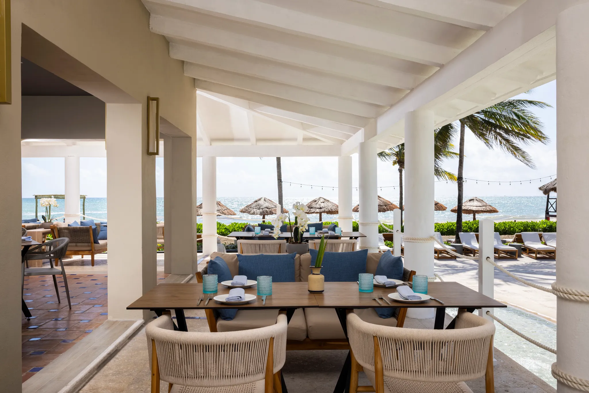 Lola Beach Snack & Bar at Hyatt Zilara Riviera Maya featuring an open-air beachfront dining area with ocean views, palm trees, and casual seating.