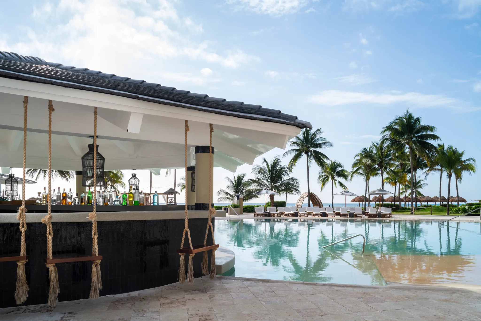 Olas Swim-Up Bar at Hyatt Zilara Riviera Maya featuring a poolside bar with in-water seating, rope swings, and tropical oceanfront views.